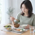 焼き魚と野菜の和定食を食べる女性